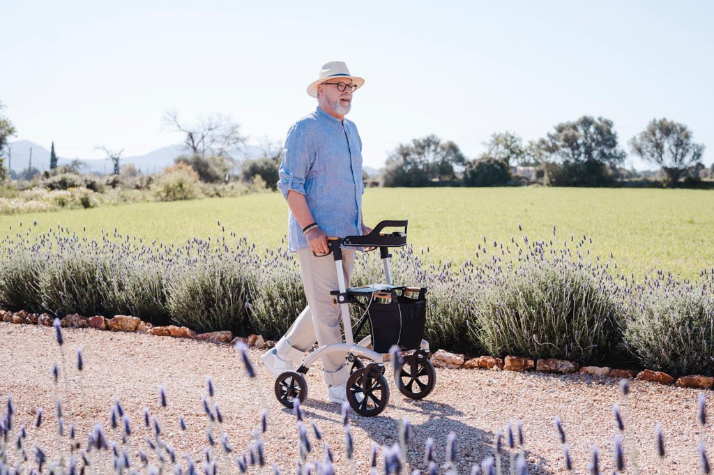 A man walks on a garden pathway with a Saljol Walker