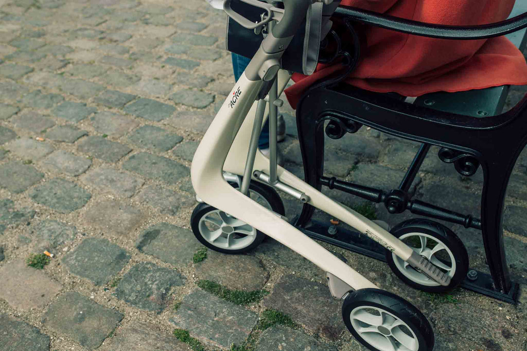 A close up of the white frame of a 'byACRE Carbon Ultraight' rollator