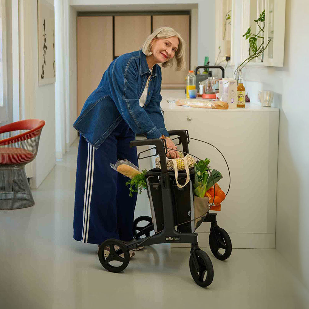 Woman using a rollator with groceries in a kitchen