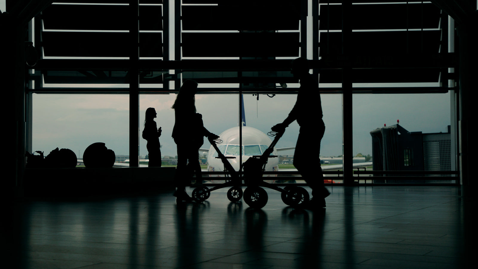 People walk through an airport terminal with byACRE walking frames